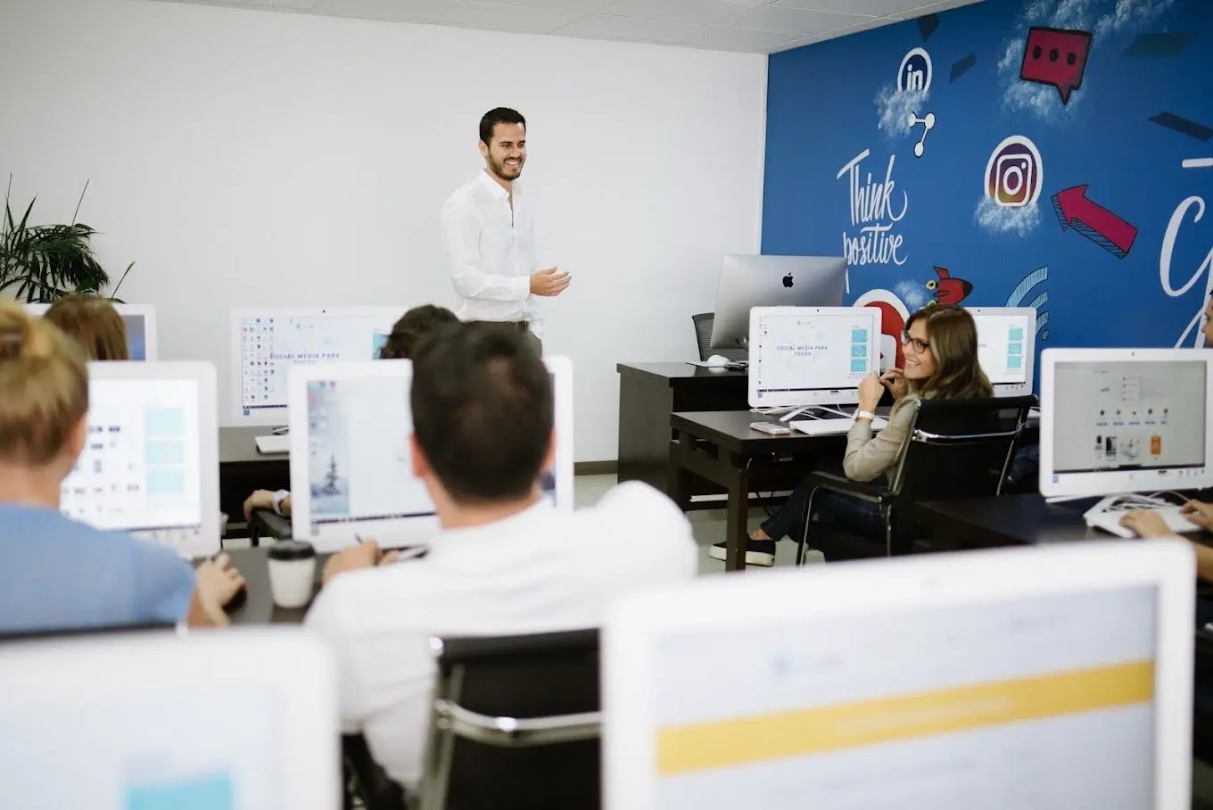 Profesor de EscuelaSM sonriendo frente a su clase