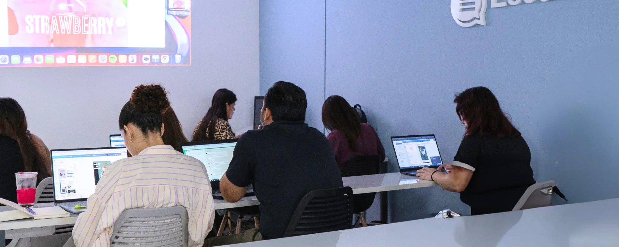 Alumnos de EscuelaSM trabajando en sus campañas en laptops